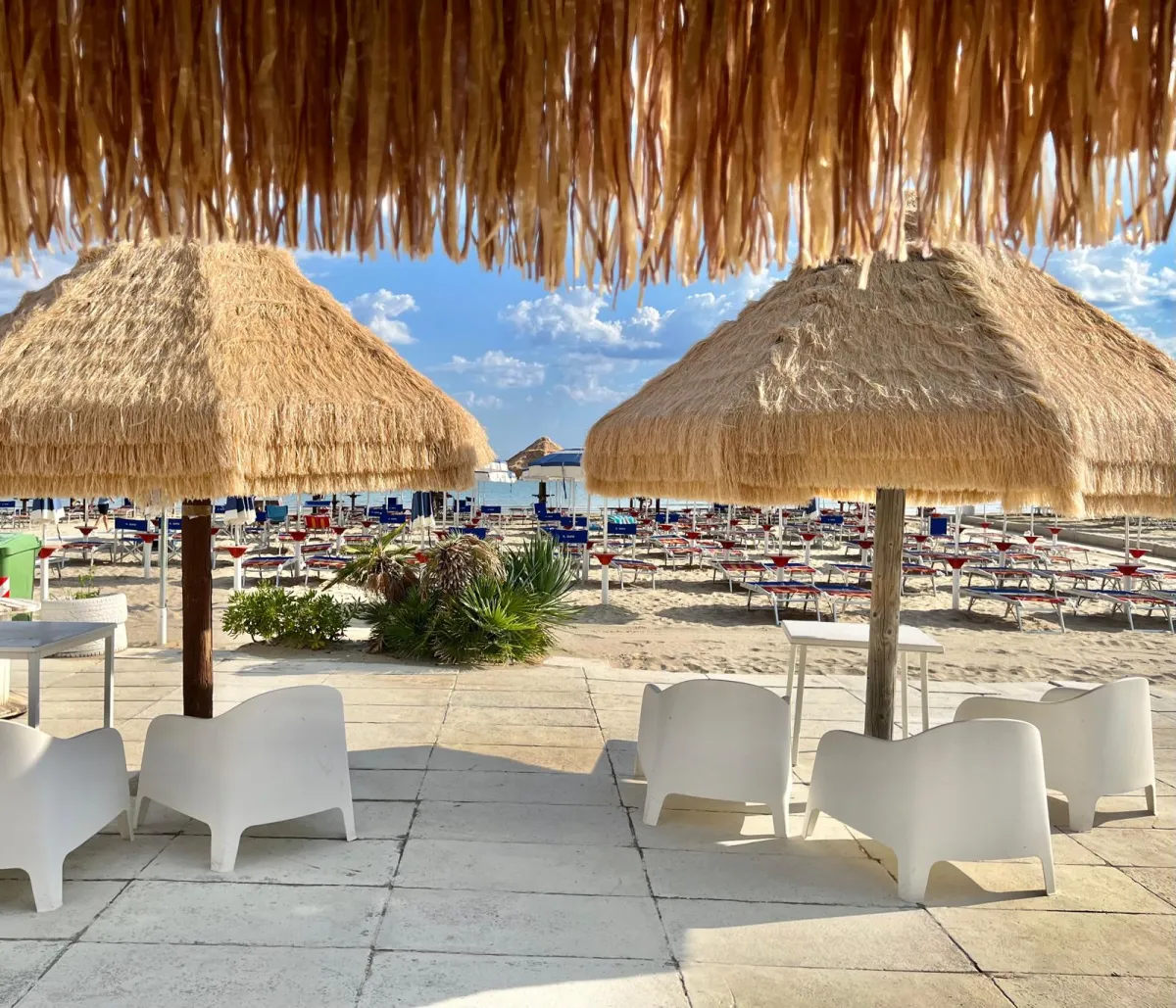 Area relax sotto il pergolato con poltroncine bianche